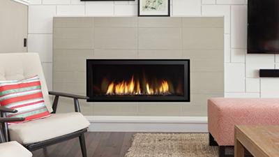 Medium direct vent contemporary fireplace, 40" wide with clean edge installation. Surround and media choices including stones, pebbles and driftwood logs are available. 