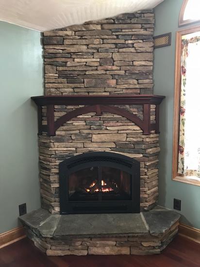 Excalibur P90 Gas Fireplace, shown with stone and custom mantel